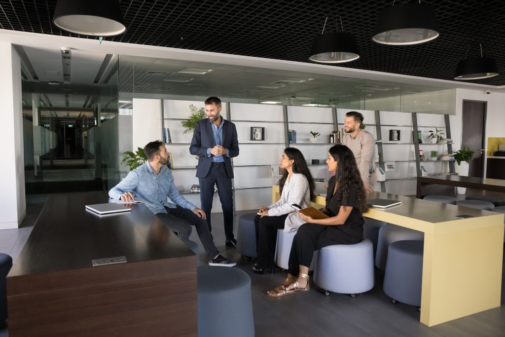 Creating ideas. A mid-aged businessman ceo boss, chief gathers diverse multicultural department staff workforce at a comfy coworking space to collaborate on a creative project in an informal, casual group meeting.